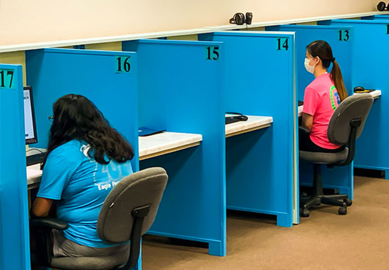 Students sitting a partitioned desks 