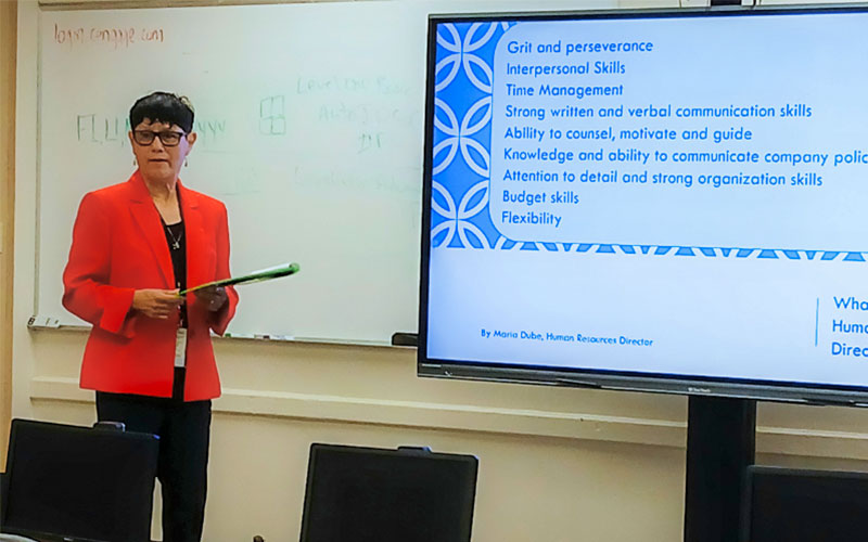 SWTX Human Resources Director Maria Dube stands in front of a Business Principles classroom during a presentation to students.